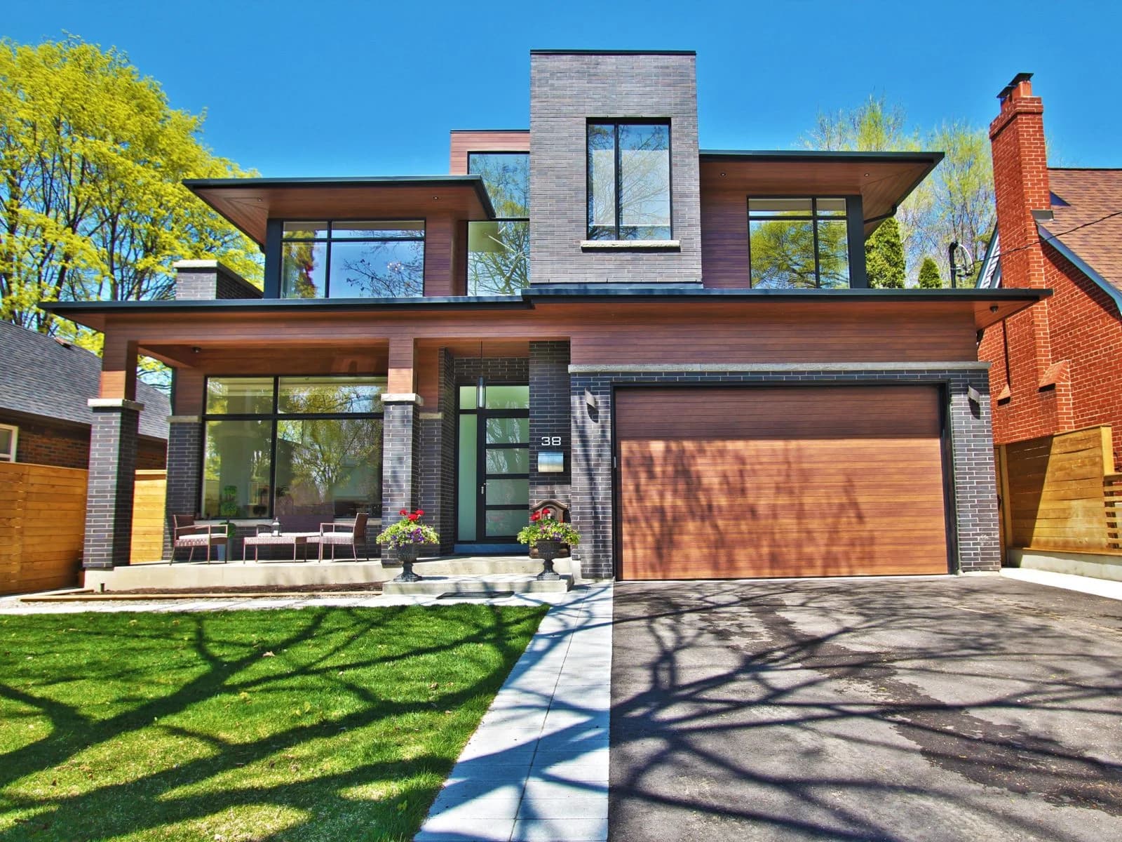 Modern infill build in the GTA, charred-cedar and dark brick cladding beside a red-brick Victorian neighbour